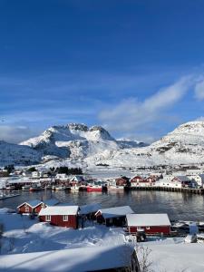a harbor covered in snow with mountains in the background at Lofoten Planet Studio in Sørvågen