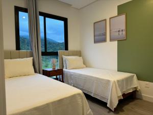 2 camas en una habitación con 2 ventanas en OKA Praia Brava - Norte en Itajaí