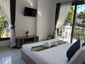 a bedroom with a large bed with towels on it at Kata Sea Blue Villa in Kata Beach +12 photos
