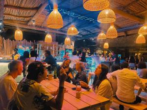 un grupo de personas sentadas en una mesa en un restaurante en Viajero Kokopelli Huacachina Hostel, en Ica