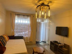 a living room with a bed and a chandelier at J L appartment in Eldoret