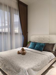 un osito de peluche tirado en una cama en un dormitorio en Georgetown Comfy Homestay, en Jelutong