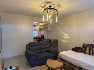 - un salon avec un lit et un canapé bleu dans l'établissement J L appartment, à Eldoret