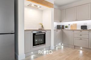 a kitchen with white cabinets and a stove at Spacious 3-bed House in Nottingham by Renzo, Amazing Location, Sleeps 6! in Nottingham