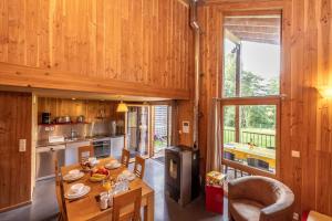 cocina y comedor con mesa y sillas en Camping Le Lac des Sapins, en Cublize
