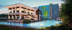 a hotel with a swimming pool in front of a building at New 8 Spatial Davao Smart Studio Unit Netflix Wi-Fi Amazon Voice Controlled Lights in Davao City