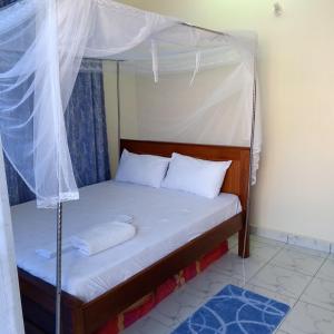 a bed with a canopy in a room at Bamburi One Bedroom Apartment in Mombasa