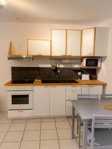 a kitchen with white cabinets and a table at Bienvenue au parc St Pierre in Amiens