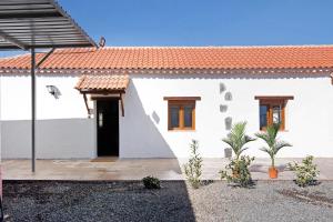 een wit huis met een rood dak bij La Tirajanera 1 in Vega de San Mateo