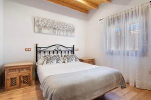 een slaapkamer met een groot bed en 2 ramen bij La Tirajanera 1 in Vega de San Mateo