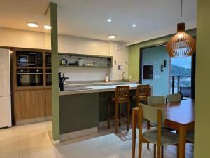 a kitchen and dining room with a table and chairs at OKA Praia Brava - Norte in Itajaí