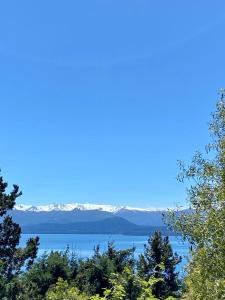 uma vista para um lago com montanhas cobertas de neve em Otto House em San Carlos de Bariloche