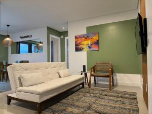 sala de estar con sofá blanco y silla en OKA Praia Brava - Norte en Itajaí