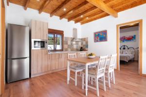 a kitchen and dining room with a table and a refrigerator at La Tirajanera 2 in Vega de San Mateo