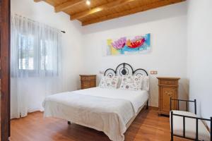 a bedroom with a large white bed and a window at La Tirajanera 2 in Vega de San Mateo