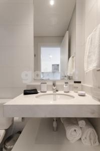 Baño blanco con lavabo y espejo en Perfect Retreat In Asuncion's Best Neighborhood, en Asunción