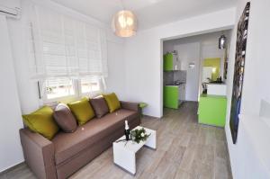 a living room with a brown couch and yellow pillows at De Sol in Limenaria