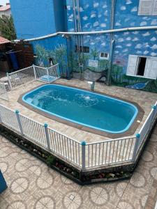 uma grande piscina com uma cerca branca à volta em Pousada Cantinho Azul em Passo de Torres