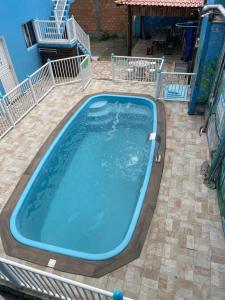 una gran piscina azul en un patio en Pousada Cantinho Azul, en Passo de Torres