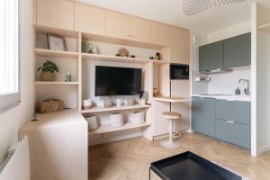 een woonkamer met een tv en een keuken bij Studio refait à neuf avec Parking en Bord de Loire in Nantes