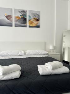 1 dormitorio con 1 cama y 2 toallas blancas en Quintino Sella, en Bari