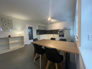 a kitchen and dining room with a wooden table and chairs at Monteurwohnung Villa Waffi in Bippen +4 photos