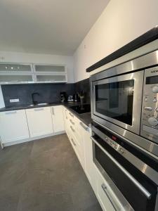 a kitchen with white cabinets and a microwave at Monteurwohnung Villa Waffi in Bippen