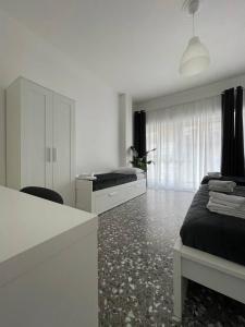 Habitación blanca con 1 cama, escritorio y 1 dormitorio. en Quintino Sella, en Bari