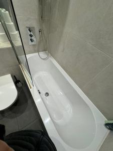 a white bath tub in a bathroom with a toilet at Two bed in Clapham in London