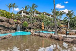 a pool at a resort with a waterfall and palm trees at Ho'olei Unit 12-2, Close to Pool, Walk to Beach in Wailea