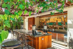 an outdoor kitchen with a bar with stools at Ho'olei Unit 12-2, Close to Pool, Walk to Beach in Wailea