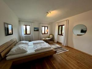 een slaapkamer met een groot bed en een spiegel bij Kärntner Bauernhaus in Panoramalage in Laas