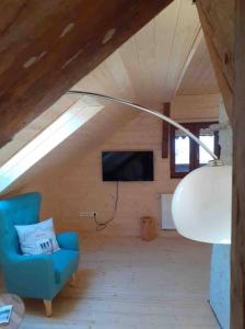 uma sala de estar com uma cadeira azul e uma televisão em Penthouse im Bauernhaus em Laas