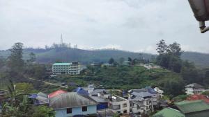 a town on a hill with houses and buildings at Achus Holidays in Munnar