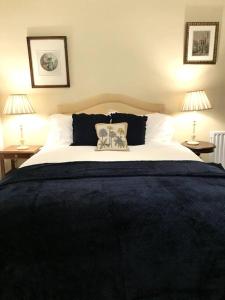 a bedroom with a large bed with two lamps at Cosy Wee Cottage St Andrews 20 in Ceres