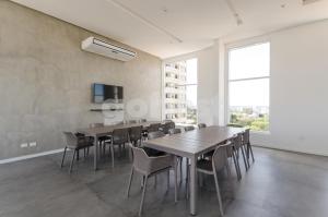 un comedor con mesas y sillas y una gran ventana en Perfect Retreat In Asuncion's Best Neighborhood, en Asunción