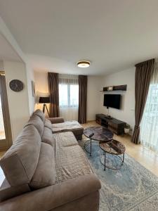 een woonkamer met een bank en een tv bij Esmeralda Suites in Calpe