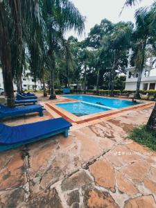 a swimming pool in a resort with palm trees at Royal Palms Mtwapa Apartments in Mtwapa