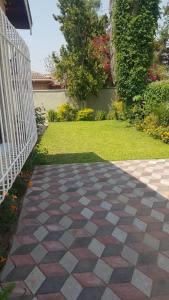 a brick walkway with a fence and a yard at Broadhurst Homestay in Gaborone
