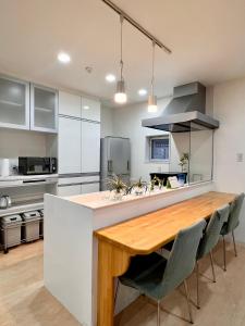 a kitchen with a wooden table and chairs at Shima Stay holoholo in Zamami