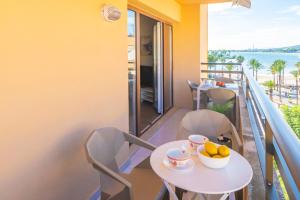 a balcony with a table and chairs with a view of the ocean at Novi in Port d'Alcudia