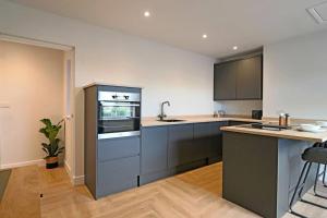 a kitchen with gray cabinets and a counter top at Luxurious Modern Retreat in Melbourne