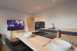 a kitchen with a counter with a sink and a tv at Luxurious Modern Retreat in Melbourne