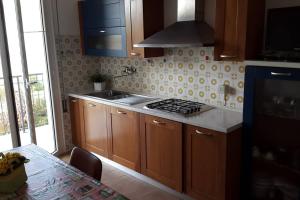 een keuken met houten kasten en een fornuis met oven bij Appartamento ROYAL in Gatteo a Mare