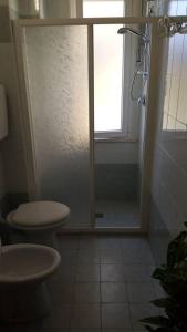 een badkamer met een toilet en een douche met een raam bij Appartamento ROYAL in Gatteo a Mare