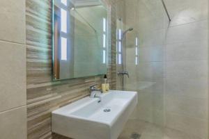 bagno con lavandino bianco e specchio di Marsaxlokk Two Bedroom Apartment 1 minute away from the seafront a Marsaxlokk