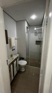 uma casa de banho com um chuveiro, um WC e um lavatório. em Pousada Pedras do Mariscal em Bombinhas