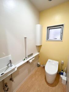 a bathroom with a white toilet and a sink at Shima Stay holoholo in Zamami