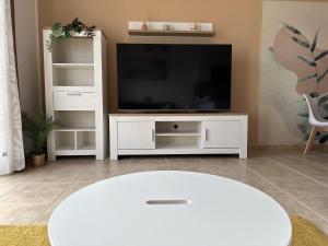 a living room with a white entertainment center with a television at Las Rocas 115 - Fuerteventura Golf Club in La Guirra
