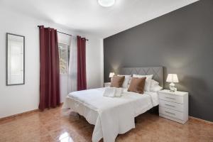 a bedroom with a large white bed with red curtains at La Tablada Atlantic Sea View in Adeje